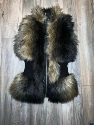 Svartbrun fuskpälsväst med dragkedja - Säljer en fluffig svartbrun pälsväs. I topp skick :)