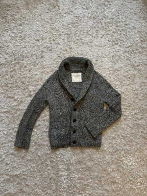 Stickad grå kofta Abercrombie & Fitch - Snygg tröja från Abercrombie & Fitch, använd men i bra skick. Storlek S! 