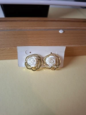 Guldiga örhängen clips med vita rosor - Fler fina accessoarer finns på min profil 💍  More exquisite accessories on my profile listings.