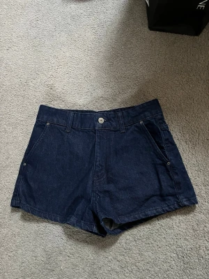 Mörkblå jeansshorts med fickor - Snygga mörkblå jeansshorts från Zara, aldrig använda. Shortsen har knapp och dragkedja framtill samt raka ben. 🤍🌷