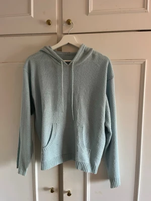 Ljusblå stickad hoodie - Mysig ljusblå stickad hoodie med huva. Har en stor magficka och ribbade muddar vid ärmslut och nederkant. Perfekt för dig som gillar en avslappnad och stilren look.💞💞såå härlig färg! Står inte storlek men passar s/m. Köpte på arkivet för 400 kr, men säljer för 170💞