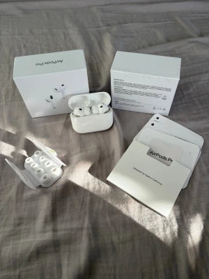Apple AirPods Pro 3 med laddetui - Säljer ett par vita Apple AirPods Pro 3 med trådlöst laddetui och flera utbytbara silikonpluggar. Hörlurarna har en stilren och kompakt design i blank plast och levereras med originalkartong och manualer. Perfekta för dig som vill ha grymt ljud och smidig anslutning.