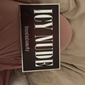 Icy Nude ögonskuggspalett Huda Beauty - Säljer en Icy Nude ögonskuggspalett från Huda Beauty med 18 nyanser i kalla, neutrala och glittriga toner. Jätte jätte bra glitter. Andvänt typ bara den guldiga. Köpt för ca 900kr