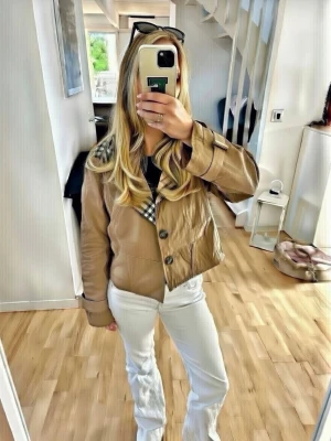 Beige trenchcoat med huva Burberry -   💓 Säljer en söt beige trenchcoat från burberry stilenmed klassiskt rutigt foder och huva, dragsko i midjan och långa ärmar. 😙 . Oops ”alla andra annonser med samma bild som min är felaktiga och säljer inte min jacka”