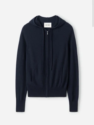 Mörkblå hoodie från Soft Goat - Mörkblå hoodie i mjuk kashmir från Soft Goat. Dragkedja framtill, två fickor och ribbade muddar vid ärmslut och nederkant. Klassisk huva med dragsko för en avslappnad look. Perfekt för dig som gillar stilrena och bekväma plagg.