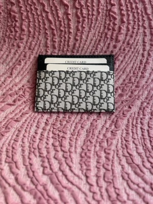   korthållare - Snygg korthållare  med klassiskt svart och grått monogrammönster. Plånboken har flera fack för kort och är tillverkad i canvas med läderdetaljer. Perfekt accessoar för dig som gillar stilrena och lyxiga detaljer. Kopia