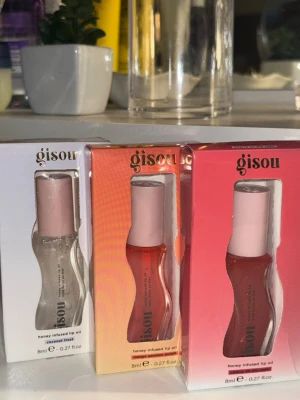 Gisou honey infused lip oil trio - Tre olika Gisou honey infused lip oil: Coconut Frost, Mango Passion Punch och Cherry on the Lips. Perfekt för glansiga och mjuka läppar.