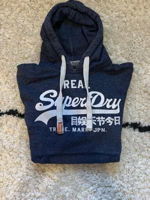 Vintage Superdry hoodie - Säljer en schyst superdry hoodie, tjocka snören. Skön och rak passform. Storlek Small. Väldig skön och mjuk material.