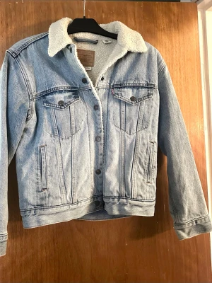 Levi's fordrad jeansjacka med teddykrage använd fåtal ggr  - Säljer en snygg ljusblå jeansjacka från Levi's med vitt teddyfoder. Jackan är använd max 3 ggr så i mycket fint skick. Ser inga tecken på användning. 