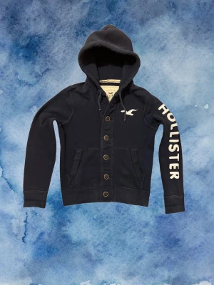 Vintage Hollister Cardigan Med Knappar (sjukt sällsynt - Säljer denna otroliga sällsynta och feta Hollister cardigan med knappar | Perfekt Skick | Längd ≈ 62cm, Bredd armhåla - armhåla 53 cm | Modell 175, 68 kg | PRIS KAN DISKUTERAS!