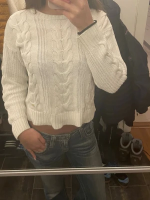 Vit stickad tröja Hampton Republic - Säljer en vit stickad tröja från Hampton Republic i storlek 170. Tröjan har ett klassiskt flätmönster, rund hals och ribbade muddar. Perfekt till kyliga dagar och enkel att matcha med jeans.