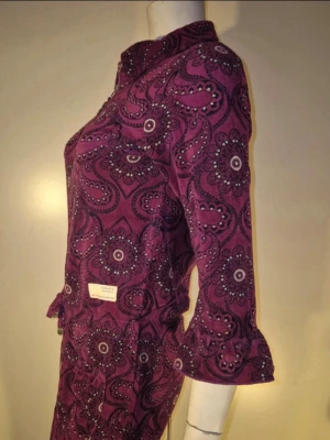 Odd Molly jumpsuit – oanvänd unik sample - Säljer en mycket ovanlig och helt oanvänd jumpsuit från Odd Molly i plommonlila/vinröd paisley.  Plagget är märkt “Sample – Not for resale”, vilket innebär att det är ett provexemplar som aldrig sålts i butik och inte går att hitta i ordinarie sortiment.  Detaljer: • Dragkedja framtill med dekorativ detalj • Knytband i midjan • 3/4-långa ärmar med lätt utsvängd manschett • Lätt utsvängda ben • Tillverkad i Portugal • Material: 80 % bomull, 20 % polyester  Storlek: Plagget saknar storleksmärkning