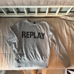 Replay sweatshirt - Säljer en skön grå tröja från Replay. Tröjan har en stor logga i svart på bröstet och ett litet r vid kragen. Storlek 150 barn vilket motsvarar ungefär xxs dam. Helt utan defekter och säljer för att den tyvärr är för kort i ärmarna, annars sitter den perfekt för mig som är ungefär 171/172🤩 