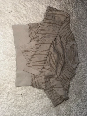 Beige träningströja med zebramönster - Säljer en beige tränings tröja från soc  med zebramönster i bruna toner