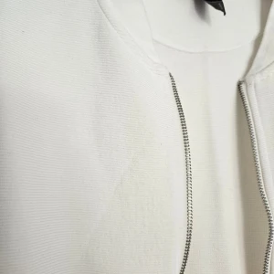 Vit slim fit kofta från H&M - Vit kofta från H&M i slim fit-modell med dragkedja framtill och diskreta fickor på sidorna. Tröjan har lång ärm och är tillverkad i mjuk bomull, perfekt för en clean och stilren look.