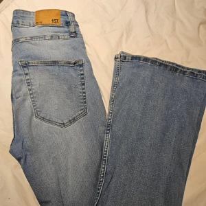 Ljusblå jeans från 157, storlek S - Ljusblå jeans från 157 i klassisk femficksmodell. Jeansen har normal passform och raka ben, med snygga kontrastsömmar och läderpatch bak i midjan. Tillverkade i mjukt denimtyg av bomull. Perfekta för en avslappnad och stilren look.