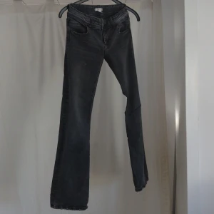 Svarta bootcut jeans - Snygga svarta jeans med bootcut passform och klassisk femficksdesign. Jeansen har en mörk tvätt och är tillverkade i ett stretchigt denimtyg som sitter skönt. Perfekta för dig som gillar en tidlös look med lite utsvängda ben. Gina youth stl 164