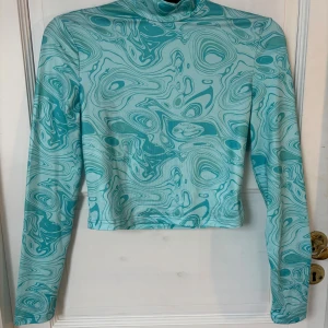 Turkos mönstrad polotopp - Mönstrad topp som bara är använd ett fåtal gånger 