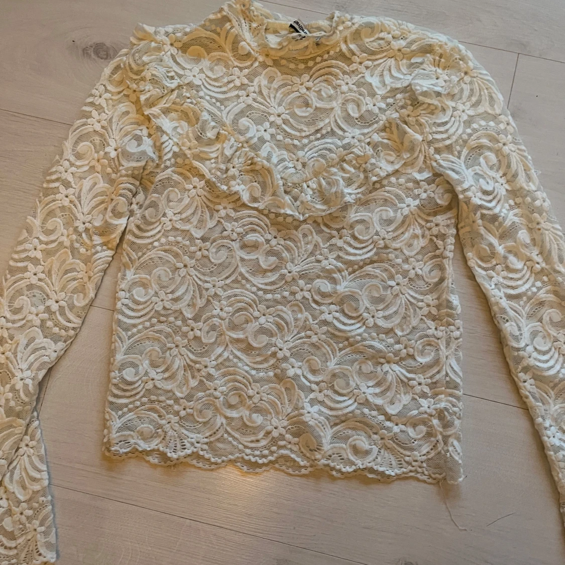 Vit spetsblus med volang