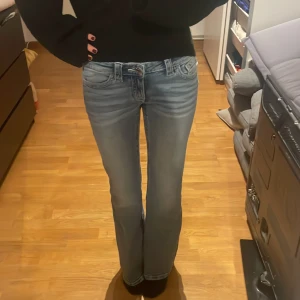 Low waist boot cut blå jeans från Gina 14+ - Snygga blå jeans med bootcut passform och låg midja. Dom är ifrån Gina 14+ så är lite längre men passar i midjan för dig som brukar ha 152 men är för lång så jeansen blir för små. Helt nya, har bara provat dom några få gånger. Aldrig haft på mig dom ute.