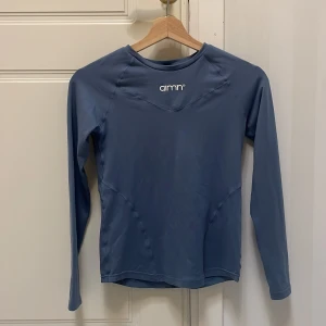 Blå långärmad träningströja Aim'n XS - Superskön blå långärmad träningströja från Aim'n i storlek XS. Tillverkad i stretchigt material med 88% polyester och 12% elastan, perfekt för gymmet eller löprundan. Snygg, enkel design med logga framtill och figurnära passform. Använd fåtal gånger, säljer då jag inte tycker färgen passar mig. 
