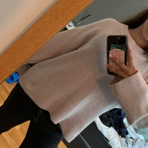 Ljusrosa stickad tröja Gina Tricot - Supermysig ljusrosa stickad tröja från Gina Tricot med breda ribbade muddar vid ärmslut och nederkant. Tröjan har en relaxed fit och rund halsringning, perfekt för lager på lager under kyliga dagar.