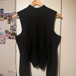 Svart stickad tröja med polokrage - Svart stickad tröja med hög polokrage och breda ärmhål. 
