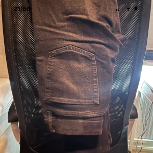 Svarta jeans från Jack & Jones - Säljer ett par Svarta jeans från Jack & Jones. Jeansen har klassisk femficksdesign, snygga sömdetaljer på bakfickorna och en slim passform. Tillverkade i mjukt bomullsmaterial med lite stretch för extra komfort.
