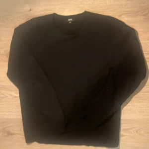 Svart stickad Uniqlo tröja - En svart, enkel och stilren tröja från Uniqlo med rund halsringning och långa ärmar. Tröjan är i mjukt material och har en klassisk passform som passar till det mesta.
