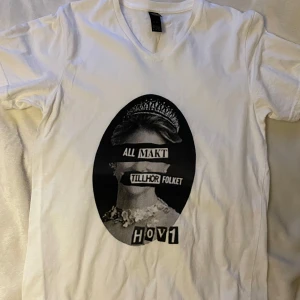 Hov1 merch - Hov1 merch från deras webbshop som sällan är öppen. Alltså svårt att få tag på denna. Köpt för 2 år sedan. Använd 2 gånger, inga fläckar eller defekter, superbra skick! V-ringad hals, vit T-shirt med tryck. Hör av er vid frågor!💕