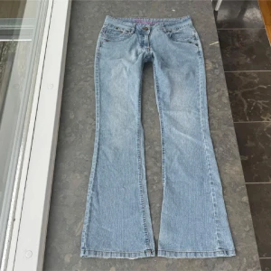 Bootcut ljusblå jeans med broderi - Lågmidjade bootcut jeans, passas storlek S. Midjemått 40cm och innerbenslängden 77cm! Inte mina egna bilder!!🥰