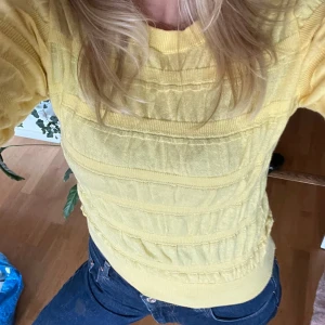 Gul stickad tröja  - Superfin gul stickad tröja från MNG med rund hals och långärmad modell. Tröjan har ett unikt ribbat mönster i horisontella ränder och sitter snyggt med en lite croppad passform. Perfekt för dig som vill ha en färgklick i garderoben!