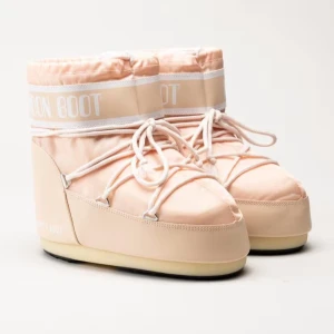 Aprikosa  Moon Boots med snörning - Säljer ett par klassiska Moon Boots i aprikos med vit snörning och detaljer. Skorna har en rund tå, platt sula och är tillverkade i syntetmaterial. Perfekta för vintern och håller fötterna varma med sin vadderade design. Kommer inte till användning längre. Storlek 38/39. Kom privat för egna bilder 