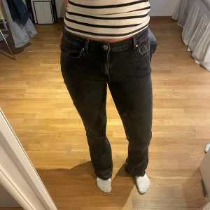Svarta bootcut jeans  - Säljer ett par svarta jeans med bootcut-modell. Jeansen har klassisk femficksdesign, normal passform och är tillverkade i jeansmaterial. Snyggt svarta med lätt urtvättad look och hög midja. Perfekta till sneakers eller boots.