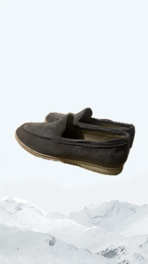 Grå mockaloafers med vit sula - Snygga loafers  i mörkgrå mocka med vit platt sula. Skorna har en stilren och minimalistisk design med rund tå och diskreta sömmar. Perfekta för dig som gillar en clean look och vill ha något som sticker ut lite lagom.