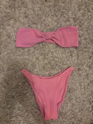Rosa bandeau bikini MC2 St. Barth - Supersöt rosa bandeau bikini från MC2 St. Barth med scrunchad textur. Överdelen är axelbandslös och underdelen har hög midja men kan enkelt bli Lågmidjad.