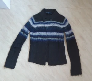 Strickad kofta från French Connection Str S - Säljer en fluffig och mysig kofta från French Connection i storlek S. Koftan är mörkblå med breda ränder i blått, vitt och grått. Den har lång ärm, hög krage och en knapp framtill. Materialet är stickat och har en lite lurvig känsla. Super snygg💕