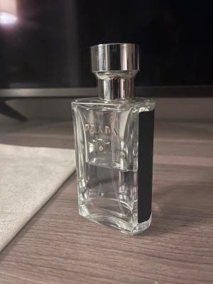 Prada L’Homme - Snygg och modern herrparfym från Prada. Flaskan har en stilren design med svart och silverdetaljer. Perfekt för dig som gillar exklusiva märken och vill sticka ut med en klassisk accessoar. 50ml kvar.
