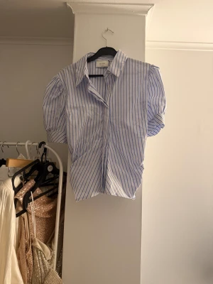 Blårandig skjorta från Neo Noir - Kortärmad skjorta från Neo Noir med blå och vita ränder och puffiga korta ärmar. 