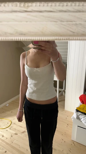 Vit ribbad linnetopp med spets från Temu - Säljer en söt vit ribbad linnetopp med smala axelband, spetskant och liten rosett framtill. Toppen är croppad och har en figurnära passform, perfekt för sommarens alla tillfällen. Aldrig använt