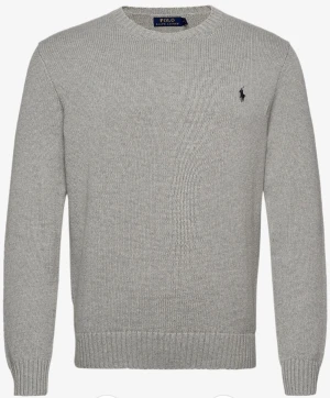 Grå stickad tröja från Polo Ralph Lauren - Snygg grå stickad tröja från Polo Ralph Lauren med klassisk rund hals och diskret broderad logga på bröstet. Tröjan har långa ärmar och ribbade muddar vid ärmslut och nederkant. Perfekt för dig som gillar stilren och enkel design.