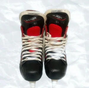 Bauer Vapor hockeyskridskor svart/röd - Säljer ett par Bauer Vapor hockeyskridskor med snygg svart och röd design, vita snören och robust plastskena. Skorna har meshdetaljer och hög komfort runt ankeln. Perfekt för dig som vill ha grym kontroll och stil på isen.
