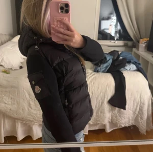 Svart Moncler pufferjacka med huva - Svart pufferjacka från Moncler. Materialet är polyester och dun, vilket gör att den värmer mer än vanliga cardigans. Skriv gärna vid behov av fler bilder. Den är i storlek 1. Pris kan diskuteras vid snabb affär. 