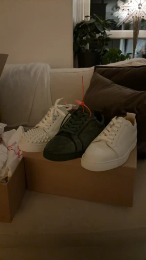 Tre sneakers i vitt och mörkgrönt - Säljer tre par sneakers, två i vitt skinn och ett i mörkgrön mocka dom 2 utan spikar är i 43,5 och dom med spikar i 44,5 alla är helt äkta med kvitto kvar då dom var för stora för mig du får med alla dustbags och box för ett pris där du knappt kan få ett par för