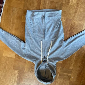 Grå hoodie från Polo Ralph Lauren - Snygg grå hoodie från Polo Ralph Lauren med dragkedja, huva och vita snören. Klassisk broderad logga på bröstet och två fickor framtill. Tillverkad i mjuk bomullsmix, perfekt för chill dagar eller när du vill ha en clean look.  •billigare på black week!