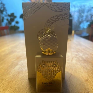 Lady White Snake Parfym 50 ml - Exklusiv parfymflaska från Stephane Humbert Lucas med namnet Lady White Snake. Flaskan har en unik design med ett guldfärgat ormhuvud som lock och en elegant vit och guld dekor. Knappast använd nypris 2200kr mitt pris 900 kr.