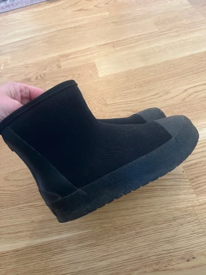 Fodrade Tretorn stl 33 - Svarta boots med kort skaft och dragkedja bak. Utsidan är i syntetmaterial och insidan är fodrad med mjukt, ljust tyg för extra värme. Sulan är grov och ger bra grepp. Perfekta för kyliga dagar när du vill hålla fötterna varma. Nypris 900:-.