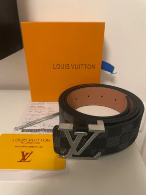 Svart rutigt bälte - Säljer ett helt nytt bälte man får med allt som är på bilden ett certifikat kvitto och en skruv för att göra extra hål