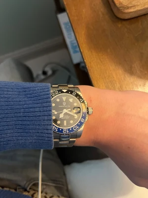 PAGANI DESIGN blå/svart klocka - Snygg PAGANI DESIGN klocka med blå och svart urtavla, silverfärgat armband i metall och tydliga siffror runt boetten. Automatisk rörelse och datumvisning. Perfekt för dig som gillar stilrena accessoarer med sportig vibe.