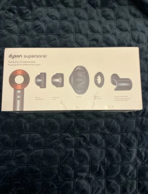Dyson Supersonic - Oöppnad med kvitto och garanti! - Dyson Supersonic hårfön med fem magnetiska stylingtillbehör: stylingkoncentrator, smoothing nozzle, diffuser, gentle air och flyaway attachment. Snabb torkning utan extrem värme, skyddar hårets naturliga glans. Produkten är i nyskick och levereras i originalförpackning.